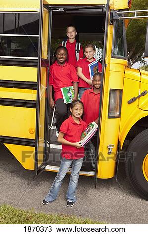 Stock Image - students standing at the door of a school bus. Fotosearch