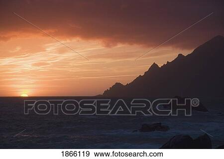 Stock Photo - Sunset over rocky coast, Porto, Corsica, France. Fotosearch