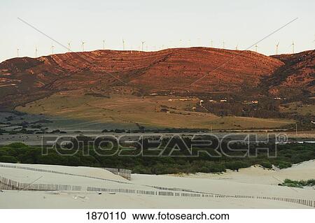 Stock Image - tarifa, cadiz, andalusia, spain; sand dune and mountain with wind turbines. Fotosearch