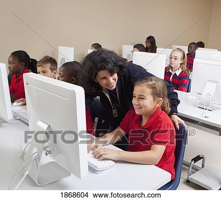 teacher helping student in computer class View Large Photo Image Picture - teacher helping student in computer class. Fotosearch