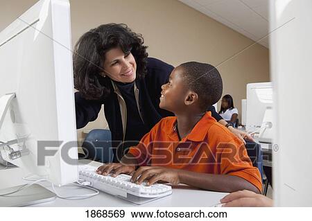 teacher helping student in computer class View Large Photo Image Stock Photo - teacher helping student in computer class. Fotosearch