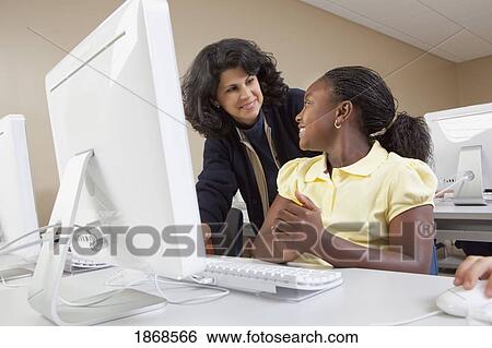 teacher helping student in computer class View Large Photo Image Stock Photograph - teacher helping student in computer class. Fotosearch