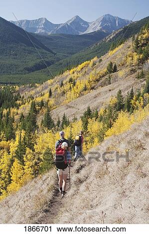 Stock Image - Three hikers walking on a mountain trail. Fotosearch