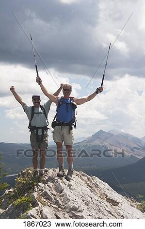 Two men cheering at the top of a mountain View Large Photo Image Stock Image - Two men cheering at the top of a mountain. Fotosearch