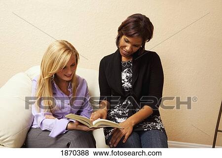 Stock Photo - two women reading the bible together. Fotosearch