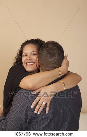 Stock Image - wife hugging her husband. Fotosearch