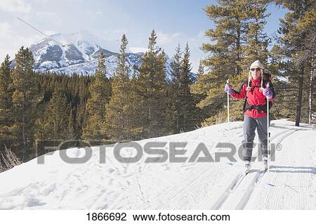 Stock Image - Woman cross country skiing in the mountains. Fotosearch