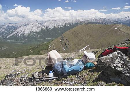 Woman hiker resting on a mountain top View Large Photo Image Stock Photo - Woman hiker resting on a mountain top. Fotosearch