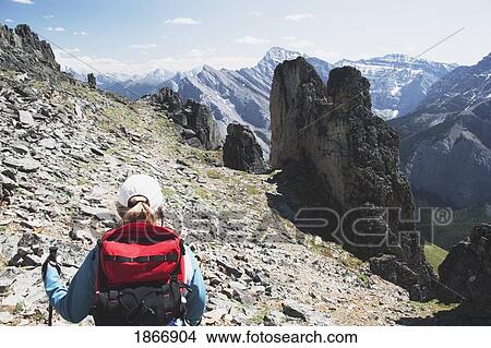 Picture - Woman hiking on a mountain trail. Fotosearch