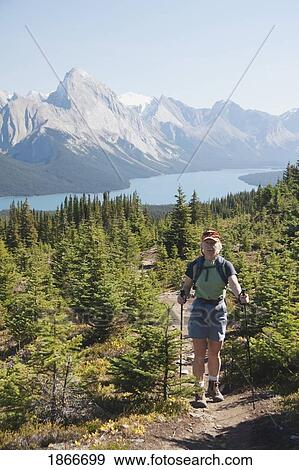 Woman hiking on a mountain trail View Large Photo Image Stock Photo - Woman hiking on a mountain trail. Fotosearch