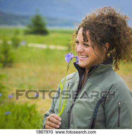 Stock Image - woman holding a flower. Fotosearch