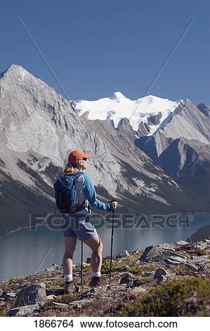 Woman looking out onto the mountains and lake View Large Photo Image Picture - Woman looking out onto the mountains and lake. Fotosearch