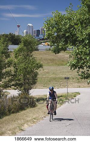 Stock Photo - Woman on a bike path in Calgary, Alberta, Canada. Fotosearch