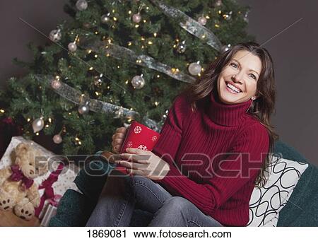 woman sitting by the christmas tree View Large Photo Image Stock Image - woman sitting by the christmas tree. Fotosearch