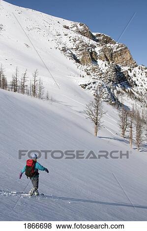 Stock Photo - Woman walking in snowshoes in the snow. Fotosearch