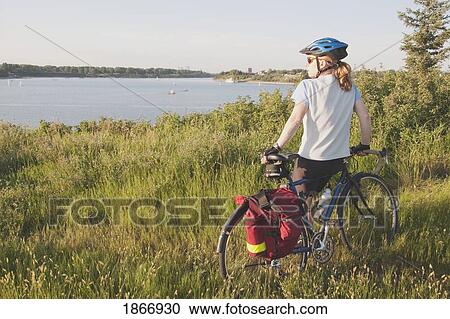 Woman with bike along a lake View Large Photo Image Stock Image - Woman with bike along a lake. Fotosearch