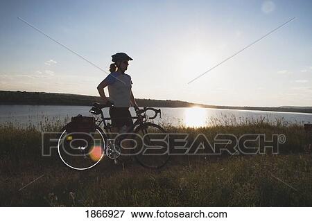 Woman with bike along a lake View Large Photo Image Stock Photo - Woman with bike along a lake. Fotosearch