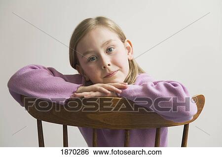 young girl with crossed arms on a wooden chair View Large Photo Image Stock Photograph - young girl with crossed arms on a wooden chair. Fotosearch