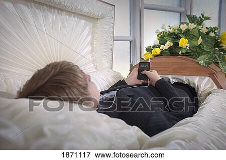 a boy laying in a coffin listening to music View Large Photo Image Stock Photo - a boy laying in a coffin listening to music. Fotosearch