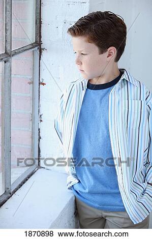 Stock Photo - a boy watching out the window. Fotosearch
