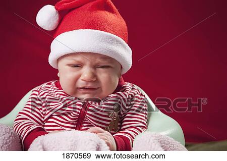 a crying infant wearing a santa claus outfit View Large Photo Image Stock Photo - a crying infant wearing a santa claus outfit. Fotosearch