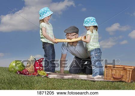 a father and two daughters having a picnic View Large Photo Image Stock Photography - a father and two daughters having a picnic. Fotosearch