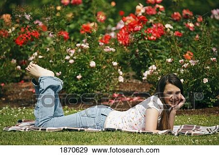 a girl relaxing on a blanket on the grass View Large Photo Image Stock Photo - a girl relaxing on a blanket on the grass. Fotosearch