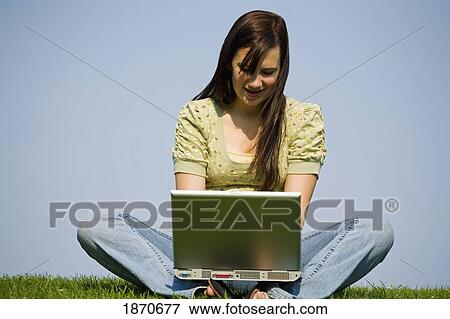 a girl working in the park on her laptop computer View Large Photo Image Stock Photo - a girl working in the park on her laptop computer. Fotosearch