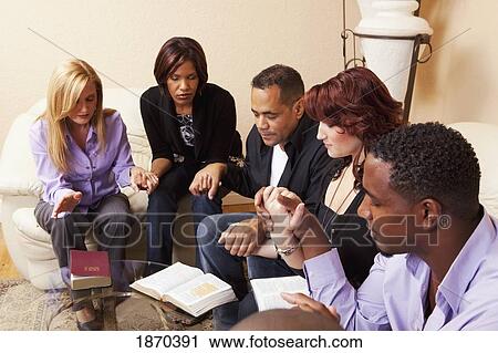 a group of adults praying together with their bibles open View Large Photo Image Stock Image - a group of adults praying together with their bibles open. Fotosearch