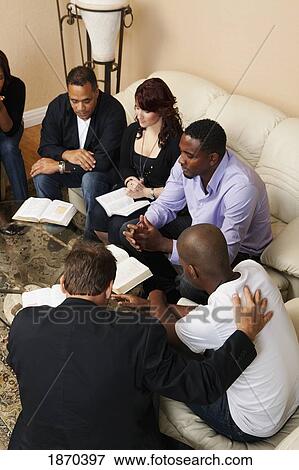 a group of adults praying together with their bibles open View Large Photo Image Stock Photo - a group of adults praying together with their bibles open. Fotosearch