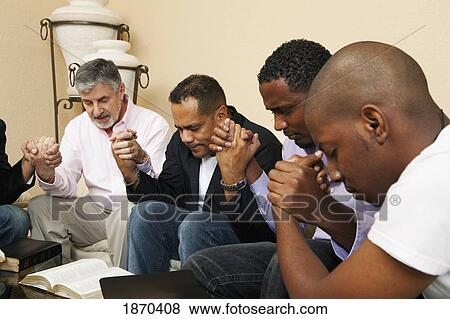 a group of men praying together with an open bible View Large Photo Image Stock Photo - a group of men praying together with an open bible. Fotosearch