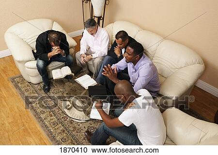 a group of men praying together with bibles open View Large Photo Image Stock Image - a group of men praying together with bibles open. Fotosearch