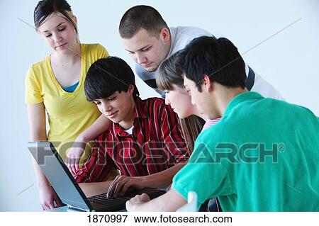 a group of teenagers looking at a laptop computer View Large Photo Image Stock Photo - a group of teenagers looking at a laptop computer. Fotosearch