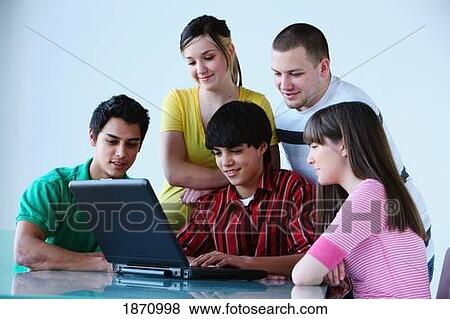 a group of teenagers looking at a laptop computer View Large Photo Image Stock Photo - a group of teenagers looking at a laptop computer. Fotosearch