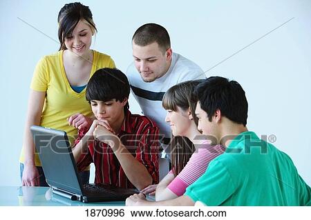a group of teenagers looking at a laptop computer View Large Photo Image Stock Photograph - a group of teenagers looking at a laptop computer. Fotosearch