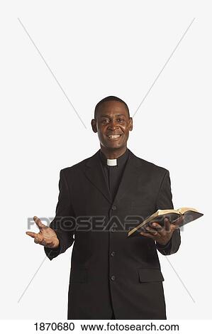 a man wearing a clerical collar and holding a bible View Large Photo Image Stock Image - a man wearing a clerical collar and holding a bible. Fotosearch