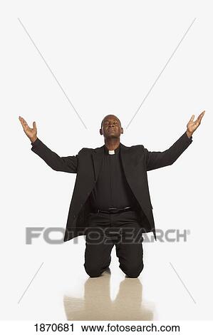 a man wearing a clerical collar and kneeling with hands raised View Large Photo Image Stock Image - a man wearing a clerical collar and kneeling with hands raised. Fotosearch