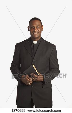 Stock Photo - a man wearing a clerical collar and holding a bible. Fotosearch