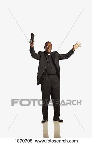 a man wearing a clerical collar and preaching from the bible View Large Photo Image Stock Photo - a man wearing a clerical collar and preaching from the bible. Fotosearch
