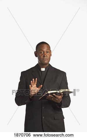 a man wearing a clerical collar and preaching from the bible View Large Photo Image Stock Photograph - a man wearing a clerical collar and preaching from the bible. Fotosearch