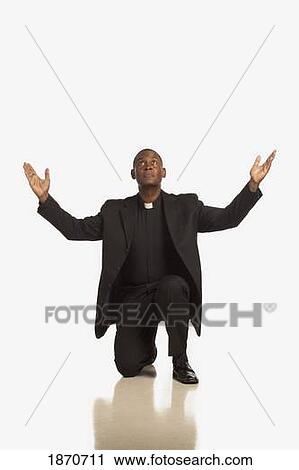 a man with a clerical collar kneeling in prayer View Large Photo Image Stock Image - a man with a clerical collar kneeling in prayer. Fotosearch