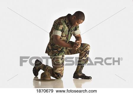 a military man kneeling with his head bowed View Large Photo Image Stock Photo - a military man kneeling with his head bowed. Fotosearch