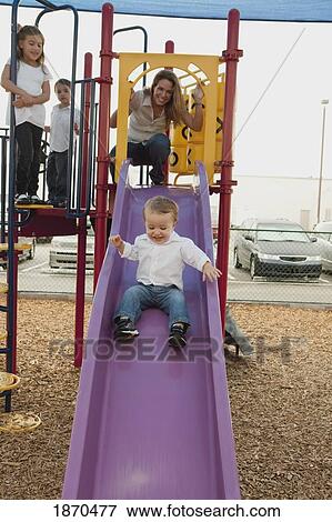 Stock Photo - a mother playing at the playground with her three children. Fotosearch
