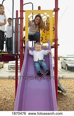 a mother playing with her three children at the playground View Large Photo Image Stock Photograph - a mother playing with her three children at the playground. Fotosearch
