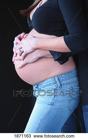 a pregnant woman's belly held by the woman's and men's hands View Large Photo Image Stock Image - a pregnant woman's belly held by the woman's and men's hands. Fotosearch