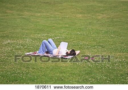 a teenage girl reading a book on a blanket in the park View Large Photo Image Stock Image - a teenage girl reading a book on a blanket in the park. Fotosearch