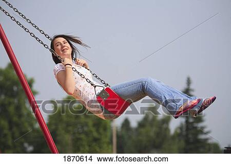 a teenage girl swinging on a swing View Large Photo Image Picture - a teenage girl swinging on a swing. Fotosearch