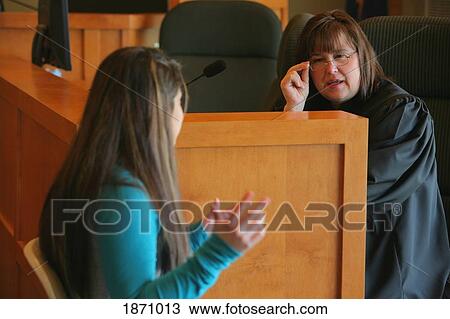 Stock Image - a teenage girl talking to a judge. Fotosearch