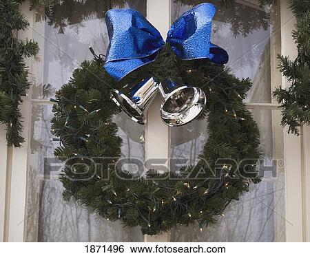 a wreath with silver bells and a blue bow View Large Photo Image Stock Photograph - a wreath with silver bells and a blue bow. Fotosearch