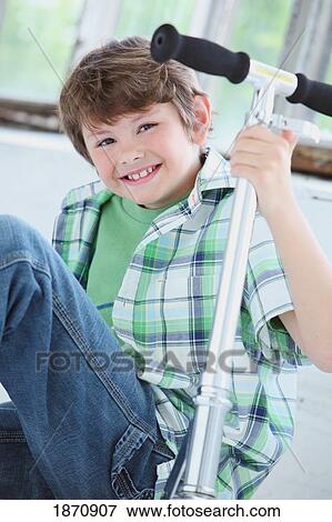 Stock Photo - a young boy with his scooter. Fotosearch